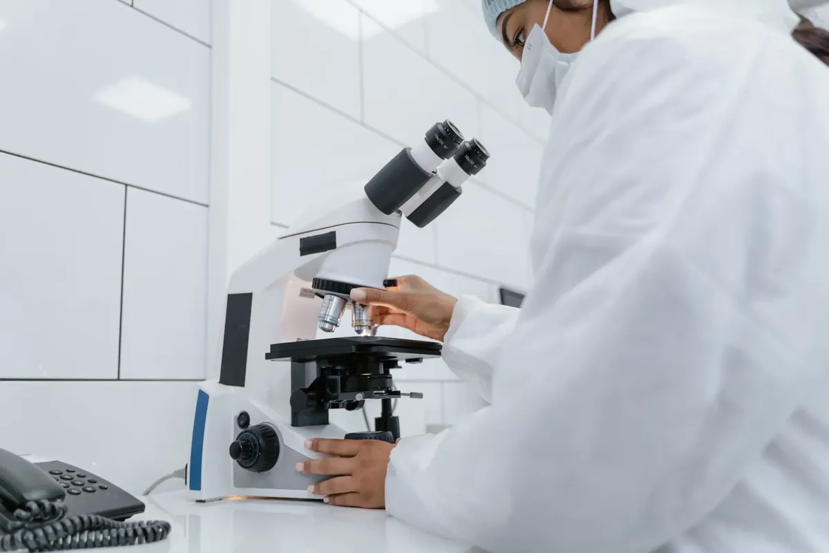 Scientist using microscope for research in a modern laboratory setting.
