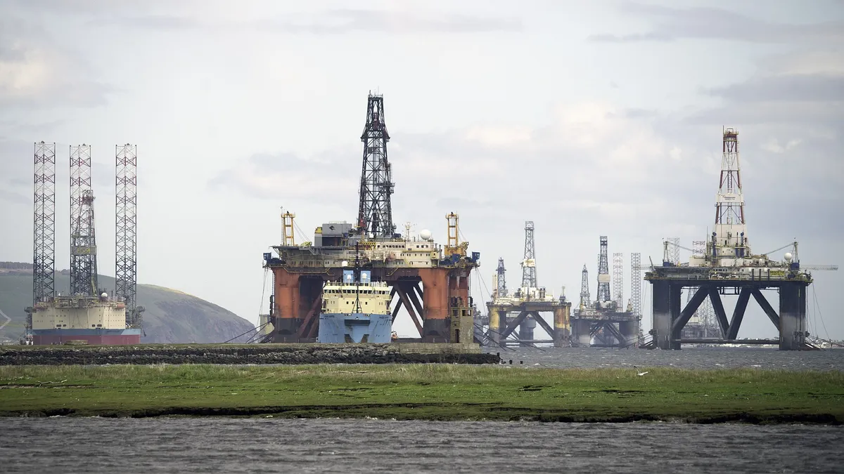 Offshore drilling rigs and a platform supply vessel lay idle on the Cromarty Firth, Scotland. New oil exploration and development of existing fields on the UK c