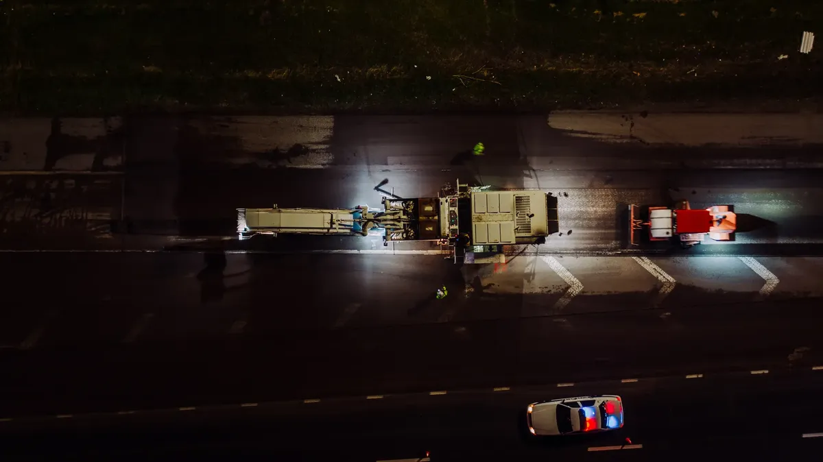 夜間 specialized 車輛開燈 repairing 道路並鋪設混凝土的頂視圖