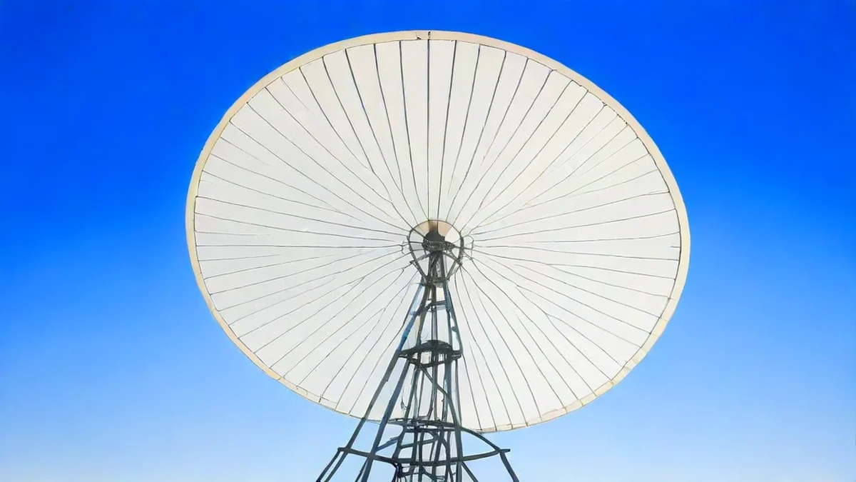 A satellite dish mounted on the ground, pointing towards the sky.