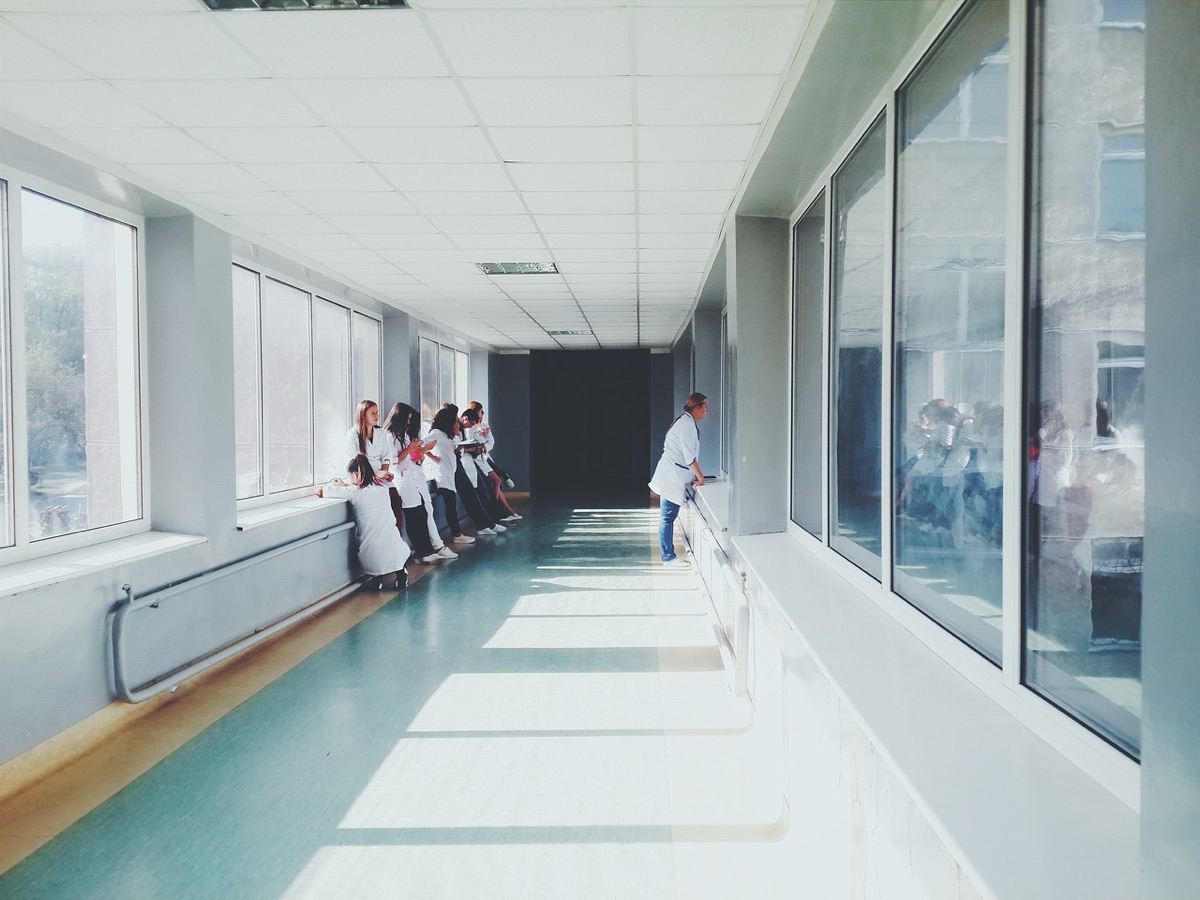 Médecin consulte un écran dans un couloir hospitalier