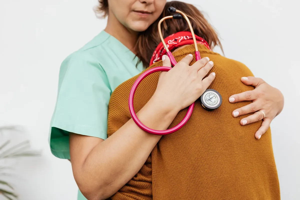 A healthcare professional offering comfort and support to a patient.