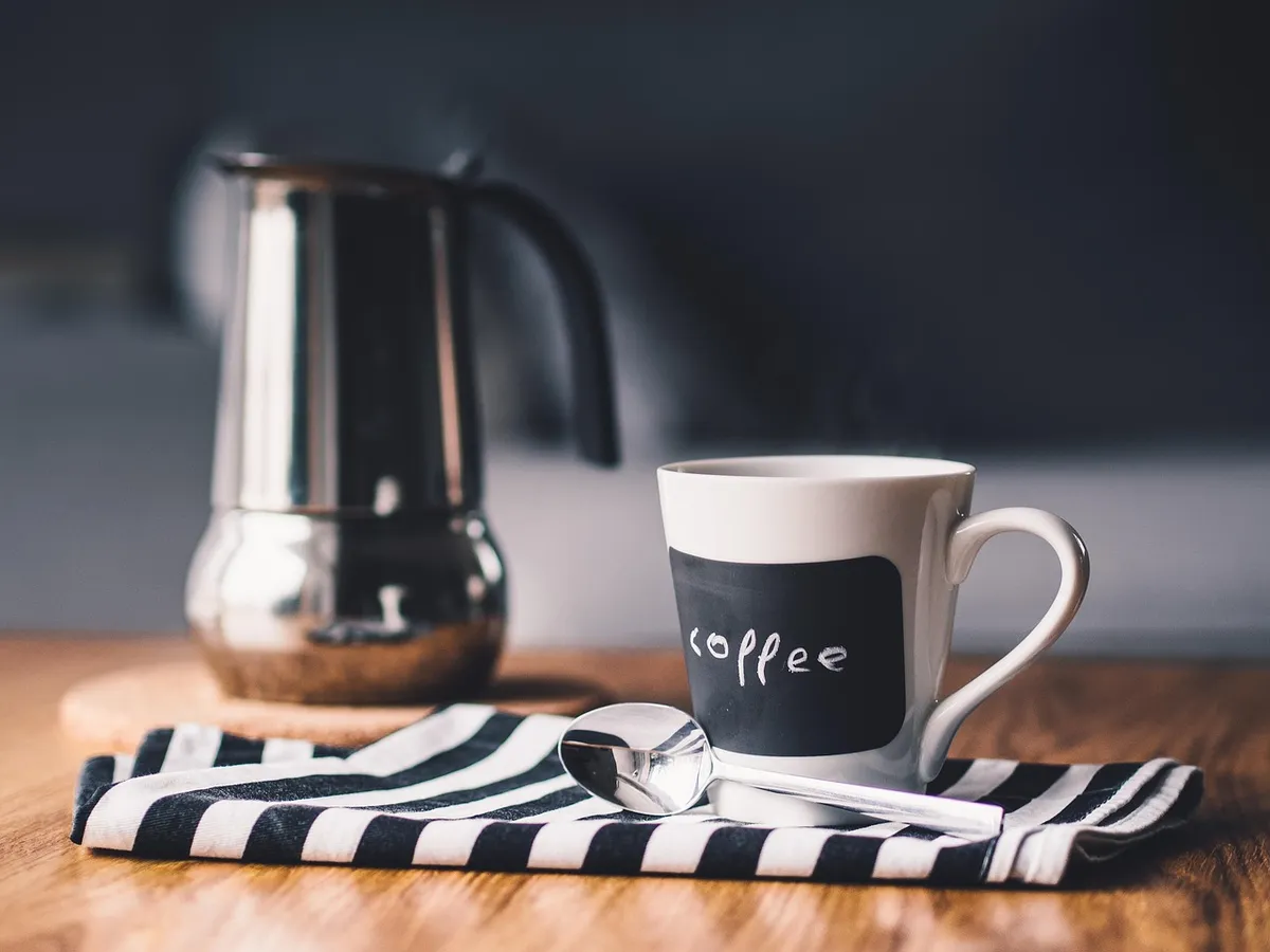 Nurse with a cold coffee cup, showing tiredness